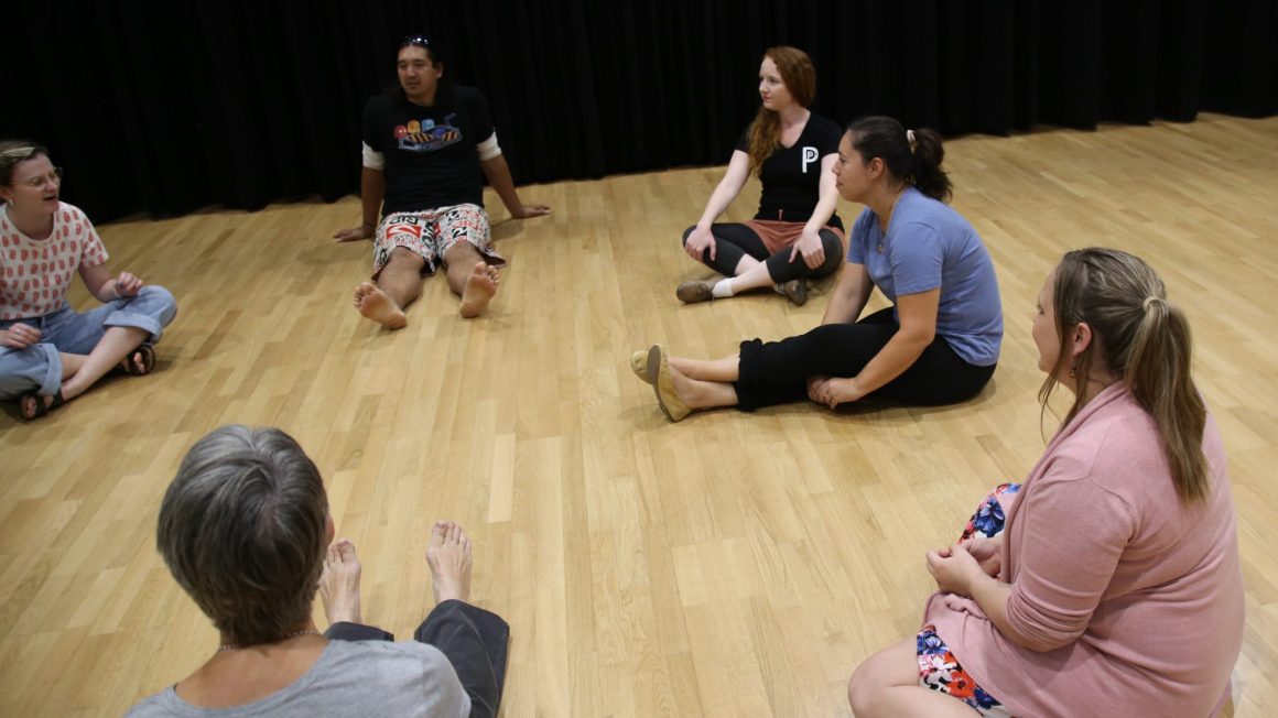 Students sitting in a circle participating in improv class